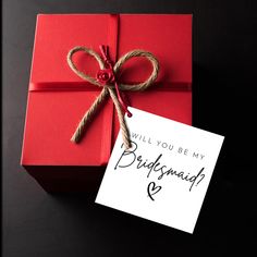 a red gift box with a note attached to it that says, will you be my bridesmaid?