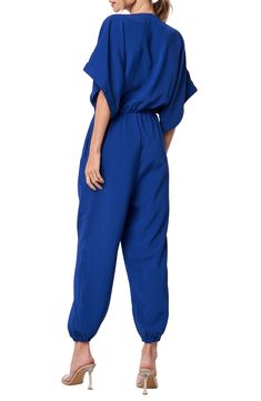 Relaxed sleeves and a tapered, jogger-inspired silhouette amplify the casual-cool style of this go-to jumpsuit. 55" length; 25" inseam; 9" leg opening (size Medium) Hidden front-zip closure Split neck Short sleeves Side-seam pockets Elastic waist Elastic ankle cuffs Unlined 100% polyester Dry clean or hand wash, dry flat Imported Asian Owned/Founded Sporty Relaxed Fit Jumpsuits And Rompers For Spring, Casual Jumpsuits And Rompers With Elastic Waistband, Sporty Blue Jumpsuits And Rompers For Spring, Blue V-neck Relaxed Fit Jumpsuits And Rompers, Blue V-neck Relaxed Fit Jumpsuit, Blue Jumpsuits And Rompers With Elastic Waistband For Spring, Ankle Cuffs, Cool Style, Elastic Waist