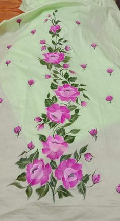 a bed with pink flowers on it and green sheets