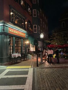 people are standing outside at night in front of the mamma marfai restaurant