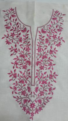 an embroidered white cloth with pink flowers and vines on the bottom, along with red thread