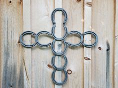 an iron cross made to look like it is hanging on a wooden wall