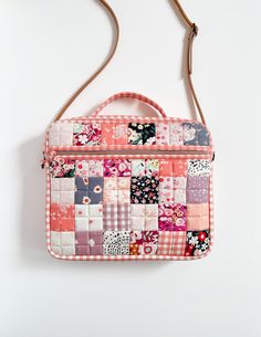 a patchwork purse hanging on a white wall