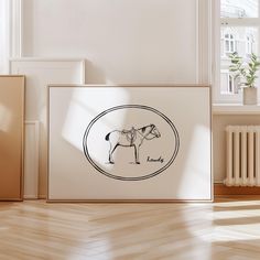 an art print with a horse in a frame on the floor next to a radiator