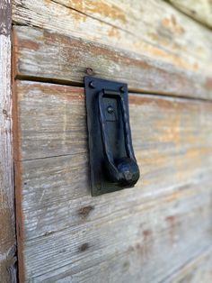 an old wooden door with a black handle on it's side and a rusted metal latch