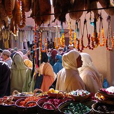 a group of people standing in front of baskets filled with fruit and veggies