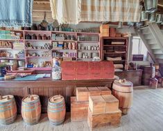 an old fashioned store with wooden barrels and bottles