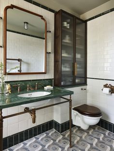 a bathroom with a toilet, sink and green counter top in front of a mirror