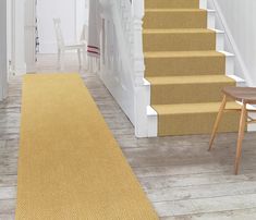 a yellow rug on the floor next to stairs