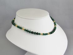 Vibrant green polished malachite beads in two sizes are interspersed with decorative vermeil spacers and shiny 14 karat gold filled beads. This statement necklace closes with a gold filled spring ring and adjustable chain for a finished length of 18 to 20 inches (46 to 51 cm). You can choose the shorter length of 16 to 18 inches (41 to 46 cm) if you prefer. Gorgeous bright green gemstone beads and quality findings make this necklace perfect for career wear and special evenings. The adjustable le Gold Spiritual Emerald Necklace With Round Beads, Gold Emerald Necklace With Round Beads And Spiritual Style, Gold Emerald Bead Necklaces, Gold Emerald Round Bead Necklaces, Malachite Necklace With Polished Beads For Gifting, Elegant Beaded Malachite Necklaces, Gold Necklace With Green Onyx Gemstone Beads, Elegant Gold Beaded Necklaces With Green Onyx, Elegant Gold Beaded Necklace With Green Onyx