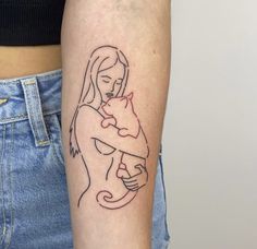 a woman with a cat tattoo on her arm is holding a baby in her arms