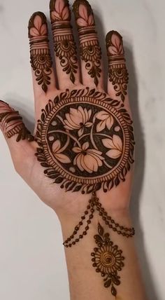 a woman's hand with henna tattoos on it