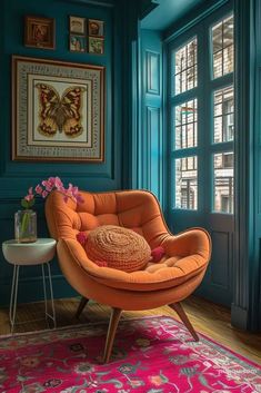 an orange chair sitting on top of a pink rug in front of a blue wall