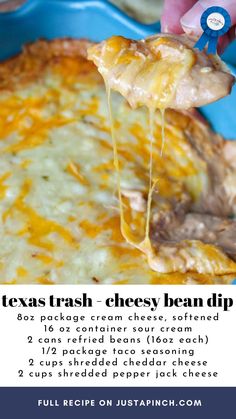 a cheesy bean dip is being held up by a person holding a spoon