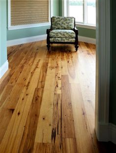 a chair sitting on top of a hard wood floor in a living room next to a window