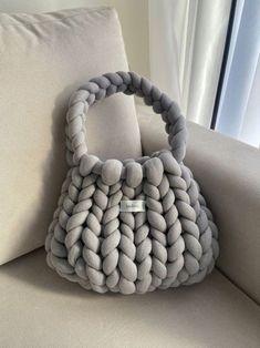 a gray purse sitting on top of a couch