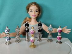 a doll with her hands out in front of a table full of different colored beads