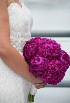 a woman holding a bouquet of purple flowers