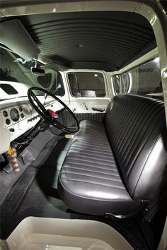 the interior of an old truck with black leather seats