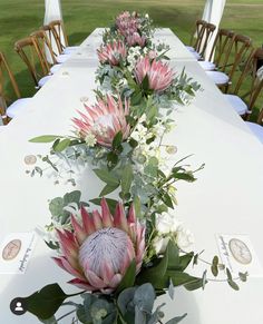 a long table with flowers and greenery on it