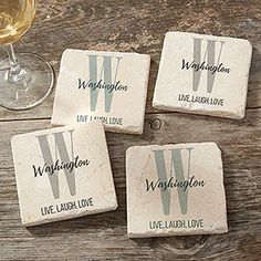 four personalized coasters sitting next to a glass of wine