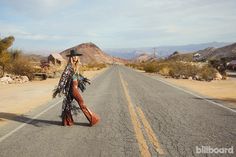 a woman walking down the middle of an empty road