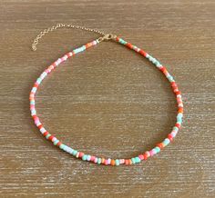 a multicolored beaded necklace on a wooden table