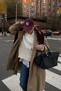 Embrace rain with these cute and casual fall outfits that add a preppy touch to your everyday style! We love this cozy rainy day outfit with beige a trench coat, jeans, a burgundy cap and a black DeMellier tote bag, for example! It's perfect for cold weather layering.