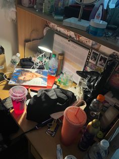 a cluttered desk with many items on it and a mirror in the back ground