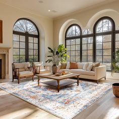 a living room filled with lots of windows next to a couch and coffee table in front of a fire place