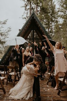 a bride and groom kissing in front of their wedding party at the end of an outdoor ceremony