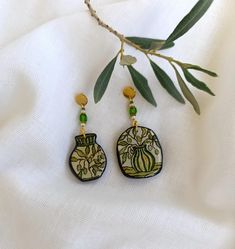 Painted Olive Branch Earrings. Grecian Goddess Mediterranean Charm Earrings. Artisan Olive Tree Earrings. Bohemian jewelry. Gift for her.  Crafted with care and attention to detail, these olive branch earrings are a perfect blend of modern and traditional style. The intricate details and vibrant colors make them a truly special piece.   Size: one earring 5,0 cm x 2,5 cm           vase earring 4,5cm x 2,0 cm Material used   Earrings   acrylic paint, polymer clay, resin covered, crystal beads, metal steel elements. Add a touch of nature to your outfit with our unique olive motif earrings. Elegant and timeless, these olive tree earrings are perfect for any occasion. Your new Earrings will be posted with register mail within 1-3 bussiness day after payment is cleared.  Feel free to contact me Paint Polymer Clay, Vase Earrings, Bohemian Jewelry Gift, Branch Earrings, Grecian Goddess, Earrings Acrylic, Tree Earrings, Earrings Bohemian, Earrings Elegant