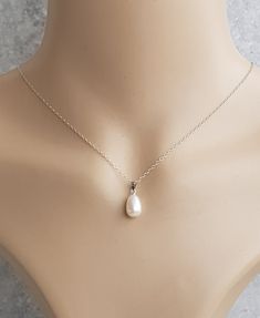 A beautiful and simple solitaire white freshwater pearl pendant on an 925 sterling silver trace chain. U.K Hallmarked 8mm x 11.5mm half drilled white freshwater pearl very good lustre  925 sterling silver bail clip and a 18inch sterling silver chain The pearls I use is are genuine freshwater pearls therefore each pearl is slightly different in shape and size and each pearl has its own unique natural blemishes. All measurements mentioned in this listing is approximate  Will be sent in a gift box Simple Silver Jewelry With Pearl Charm, Simple Silver Jewelry With Pearl Chain, Simple Silver Pearl Drop Jewelry, Simple Sterling Silver Jewelry For Formal Occasions, Delicate Silver Pear-shaped Jewelry, Delicate Pear-shaped Sterling Silver Jewelry, Sterling Silver White Gold Teardrop Pendant Pearl Necklace, Minimalist Sterling Silver Pearl Drop Necklace, White Gold Sterling Silver Teardrop Pendant Pearl Necklace