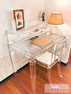 a clear desk with a lamp and pictures on it