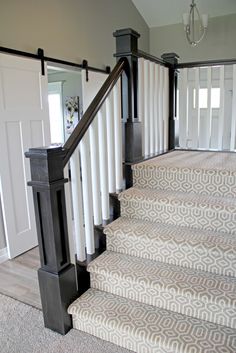 a staircase with white and gray carpeting next to a mirror on the wall above it