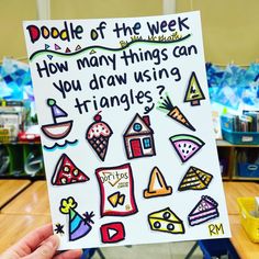 someone holding up a sign that says doodle of the week how many things can you draw using triangles?