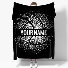 a woman holding up a black blanket with the words your name on it in white letters