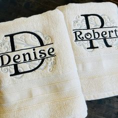 two white towels with the words denise and robert printed on them sitting on a table