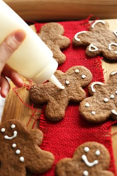 someone is decorating some gingerbread cookies with icing