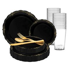 black and gold dinnerware set with plastic plates, silverware and cups on white background