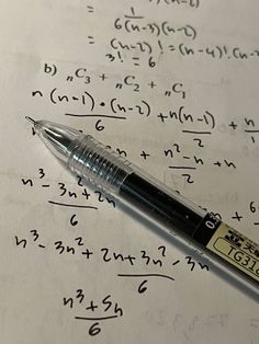 a pen sitting on top of a piece of paper with numbers and calculations written in it