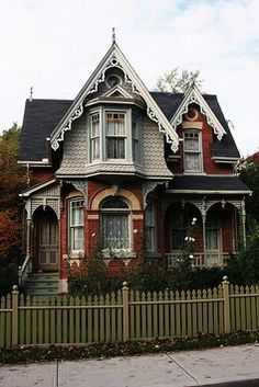 an old victorian style house with a picket fence