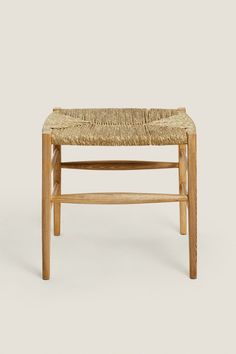 a wooden bench with woven seat padding on it's backrest and legs