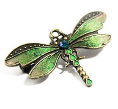 "Lovely handpainted dragonfly brooch with shimmering wings and Swarovski crystal. This little brooch is in the shape of a dragonfly - a favourite Art Nouveau motif - which I have painted with iridescent paints to create a beautiful shimmering mix of light emerald, olive and gold (quite hard to capture in photographs!).  The brooch is finished off with a Swarovski crystal jewel in an iridescent blue-green. The pin on this brooch runs horizontally across the back. It is an original design and hand Dragonfly Brooch Jewelry Gift, Dragonfly Brooch Jewelry As A Gift, Dragonfly Brooch Jewelry For Gift, Elegant Dragonfly Brooch As Gift, Elegant Dragonfly Brooch For Gift, Handmade Antique Green Brooches, Art Nouveau Jewellery, Art Nouveau Motif, Olive And Gold