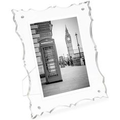 an old fashioned phone booth with a clock tower in the background