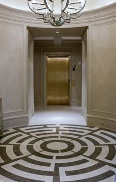 an elegant hallway with a chandelier and marble floor