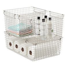 a white wire basket with three bottles and two containers in it on a white background