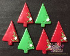 six decorated christmas trees sitting on top of a table