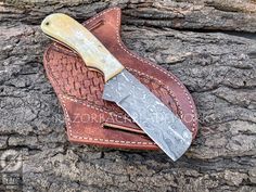 a knife and sheath sitting on top of a piece of wood