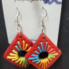 a pair of earrings with colorful designs on them